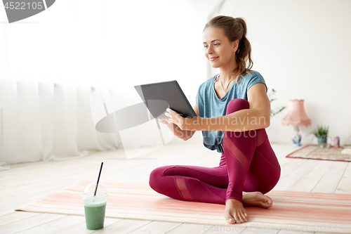 Image of woman with tablet pc and drink at yoga studio
