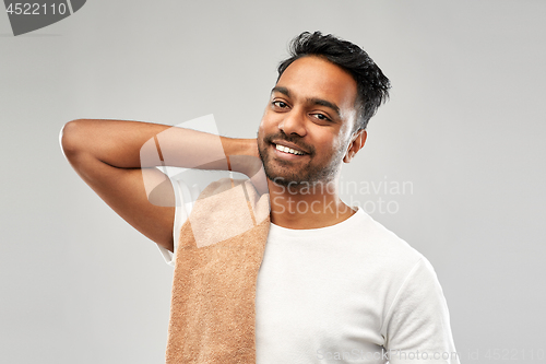 Image of smiling indian man with towel over grey background