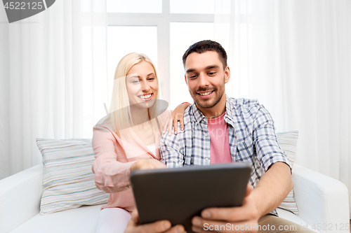 Image of happy couple with tablet computer at home