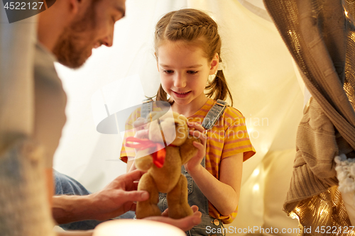 Image of happy family playing with toy in kids tent at home