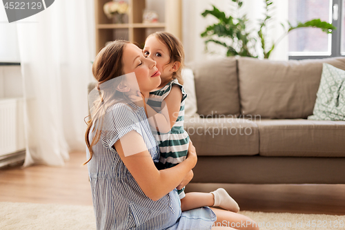 Image of pregnant mother and daughter hugging at home