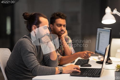 Image of creative team with computer working late at office