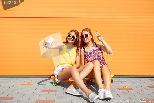 Image of teenage girls with skateboards taking selfie