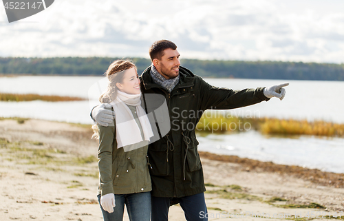 Image of couple walking along autumn beach