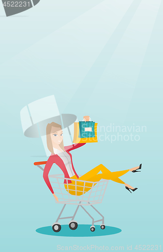Image of Young caucasian woman riding in shopping trolley.