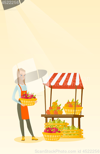 Image of Greengrocer holding box full of apples.