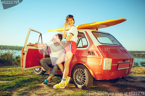 Image of Couple resting on the beach on a summer day near river