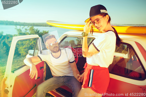 Image of Couple resting on the beach on a summer day near river