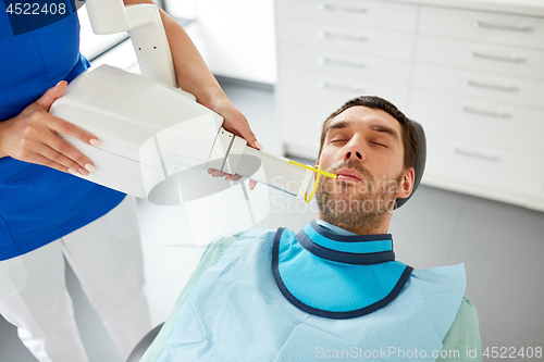 Image of dentist making dental x-ray of patient teeth