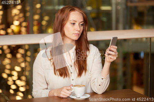 Image of woman with coffee and smartphone at restaurant