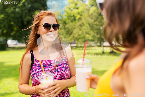 Image of teenage girls with milk shakes at summer park