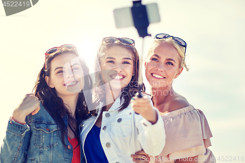 Image of group of smiling women taking selfie on beach