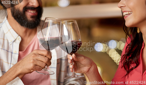 Image of happy couple drinking red wine at restaurant