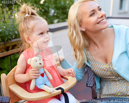 Image of mother and baby daughter at cafe looking up