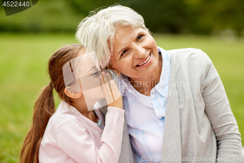 Image of granddaughter sharing secrets with grandmother