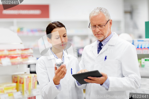 Image of apothecaries with tablet pc and drug at pharmacy