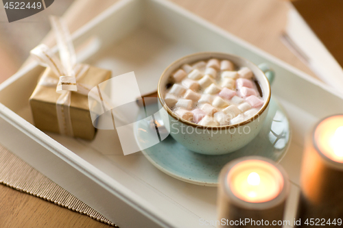 Image of hot chocolate, christmas gift and candles on table