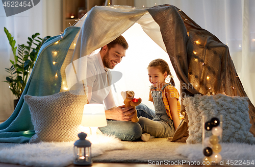 Image of happy family playing with toy in kids tent at home