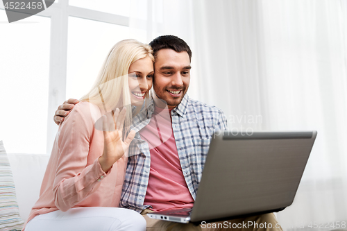 Image of couple with laptop having video call at home