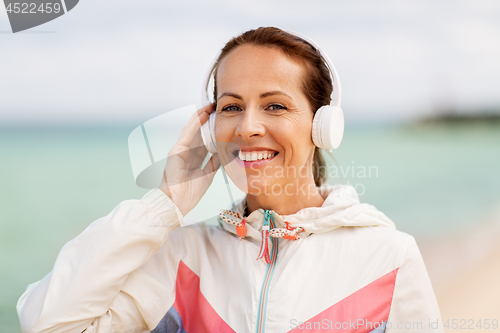 Image of woman with headphones listening to music on beach