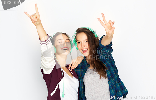 Image of teenage girls in earphones listening to music