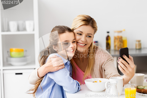 Image of family taking selfie by smartphone at breakfast