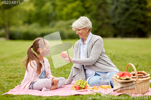 Image of grandmother and granddaughter at picnic in park