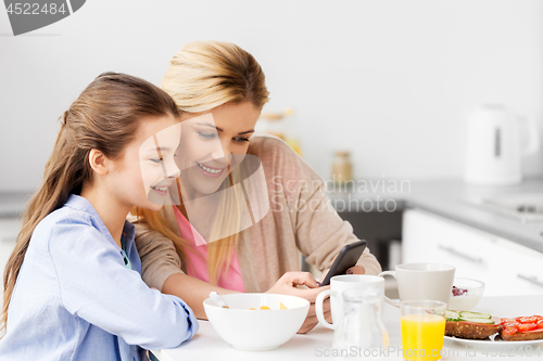 Image of family with smartphone having breakfast at home