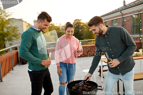 Image of happy friends having bbq party on rooftop
