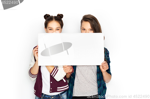 Image of happy teenage girls holding blank white board