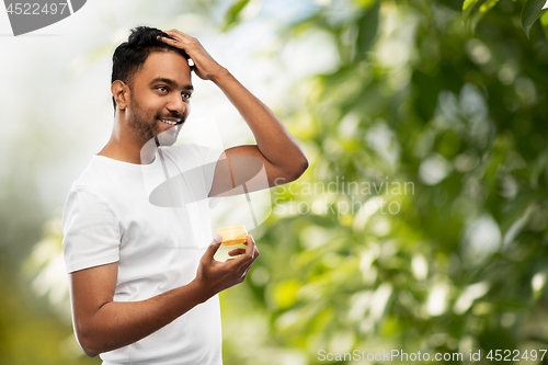 Image of indian man applying hair wax or styling gel