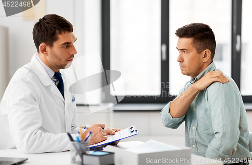 Image of patient showing sore shoulder to doctor at clinic