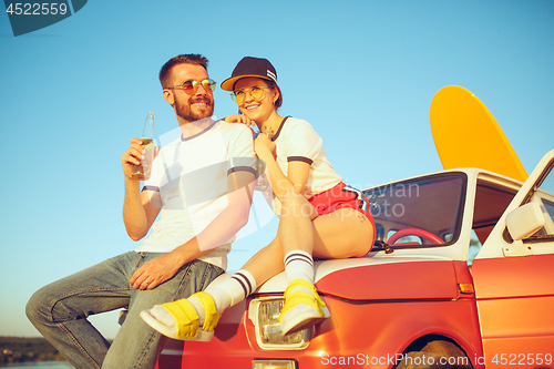 Image of Couple resting on the beach on a summer day near river. Love, happy family, vacation