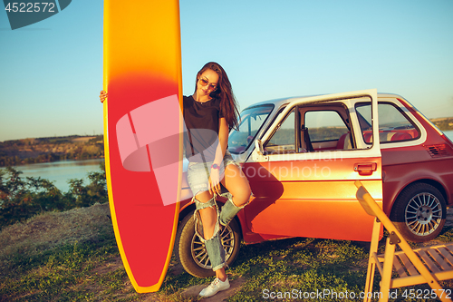 Image of The surfboard, car, man.