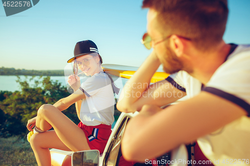 Image of Couple sitting and resting on the beach on a summer day near river