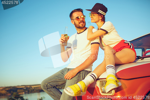 Image of Couple resting on the beach on a summer day near river. Love, happy family, vacation