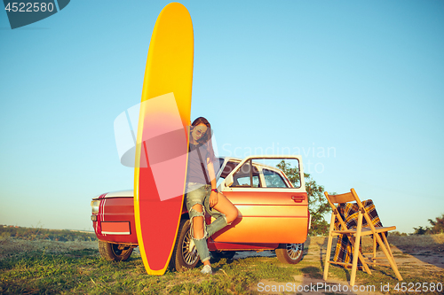Image of The surfboard, car, man.