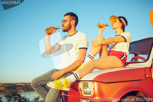 Image of Couple resting on the beach on a summer day near river. Love, happy family, vacation