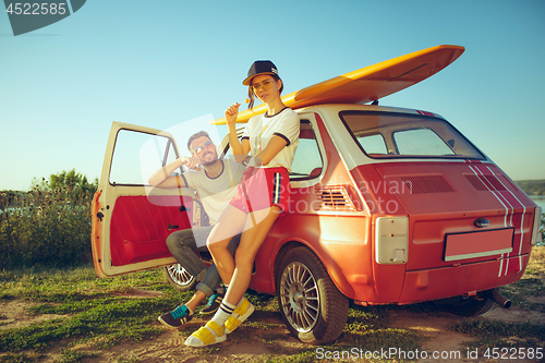 Image of Couple resting on the beach on a summer day near river