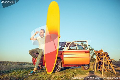 Image of The surfboard, car, man.