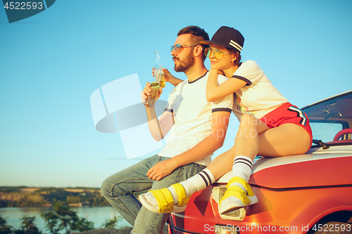 Image of Couple resting on the beach on a summer day near river. Love, happy family, vacation