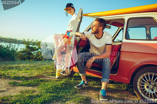 Image of Couple sitting and resting on the beach on a summer day near river