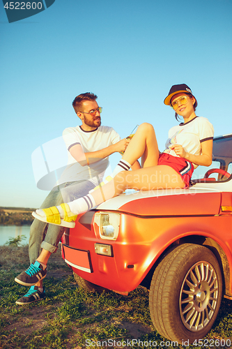 Image of Couple resting on the beach on a summer day near river. Love, happy family, vacation