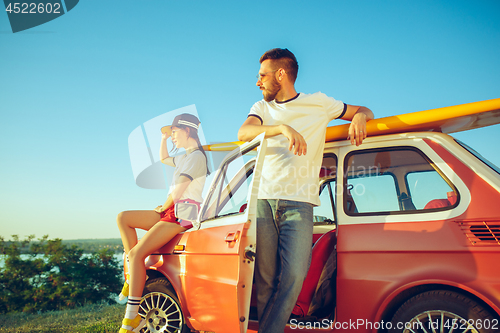 Image of Couple sitting and resting on the beach on a summer day near river