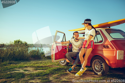 Image of Couple resting on the beach on a summer day near river