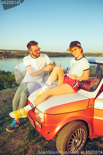 Image of Couple resting on the beach on a summer day near river. Love, happy family, vacation