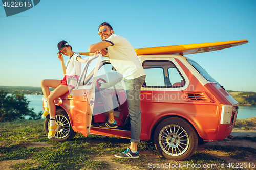 Image of Couple sitting and resting on the beach on a summer day near river