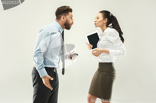 Image of Angry boss. Man and his secretary standing at office or studio