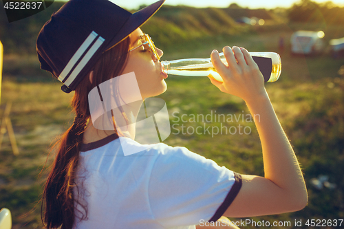 Image of Woman drinking lemonade at park