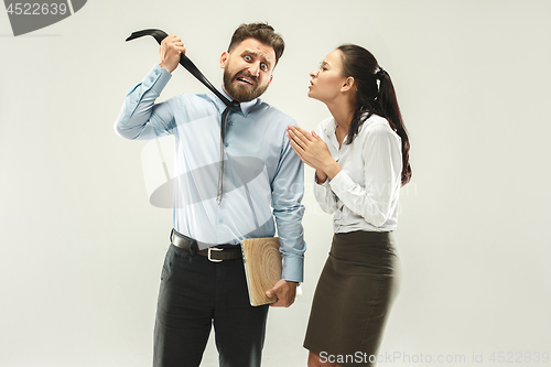 Image of Angry boss. Man and his secretary standing at office or studio